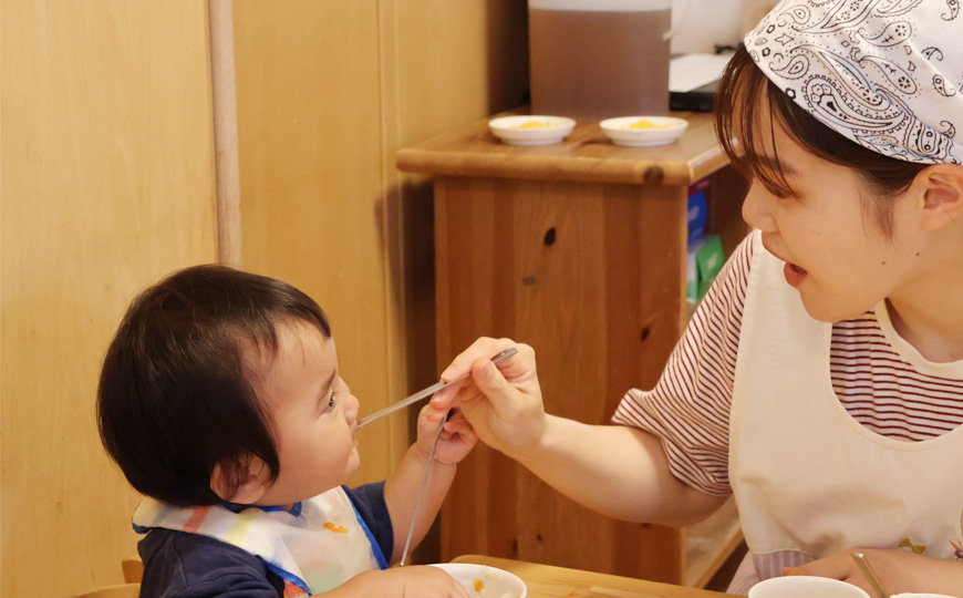 先生が園児にご飯を食べさせている